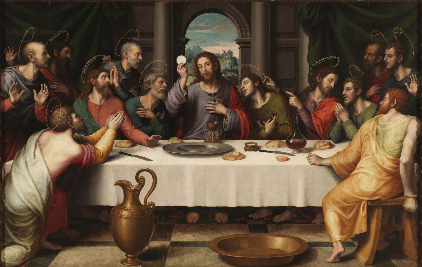 Juan de Juanes’ Last Supper: Jesus at the centre of the table holds up a round white host above a chalice, the apostles around him.